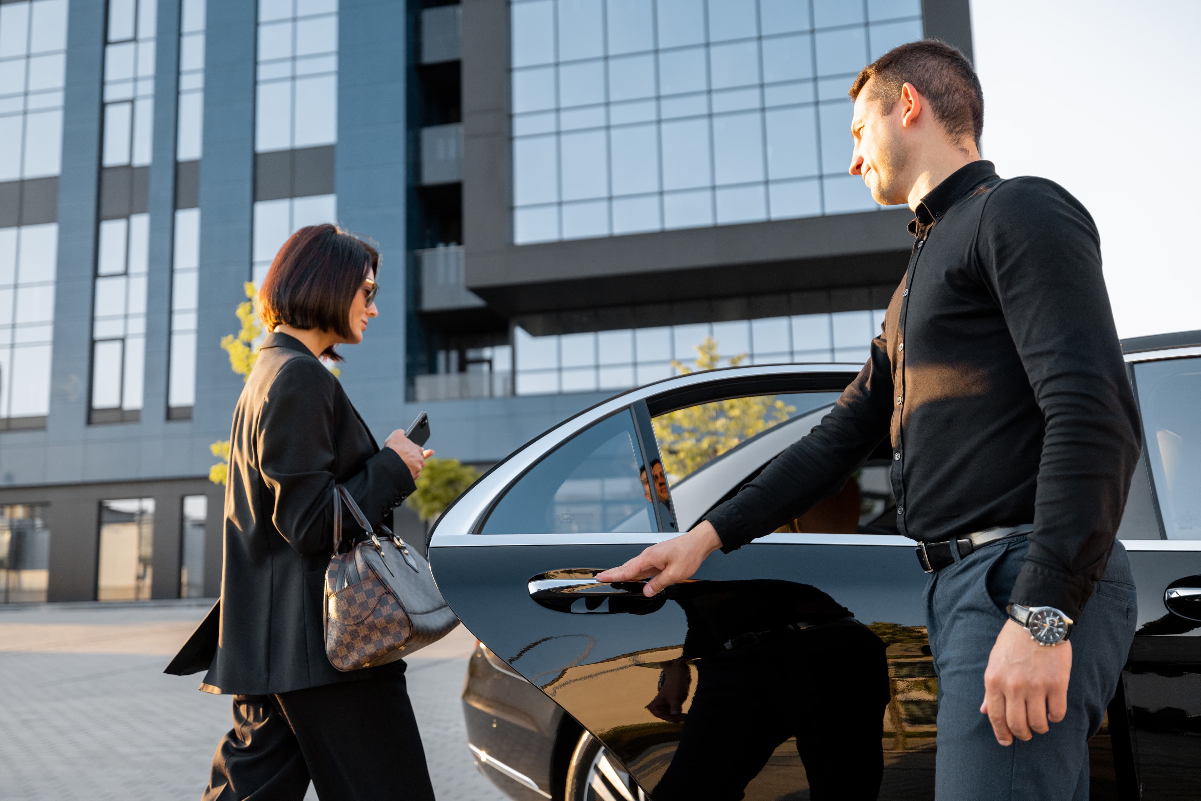 CHauffeur letting woman into car